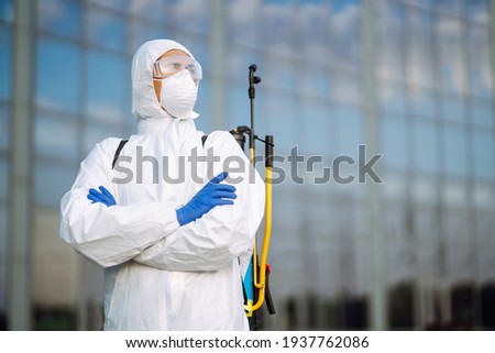 Portrait of Man  in protective hazmat suit and mask. Covid-2019. Prevention of spreading  global pandemic pneumonia virus. Royalty-Free Stock Photo #1937762086