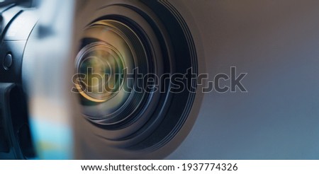  Camera lens close up and blue background  Royalty-Free Stock Photo #1937774326