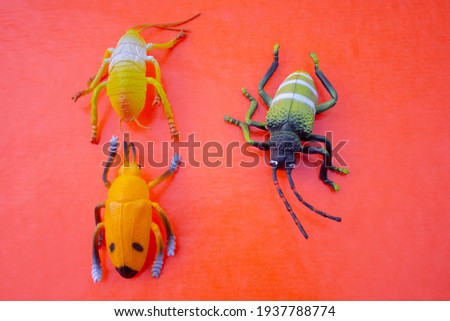 Plastic insect toys on pink background