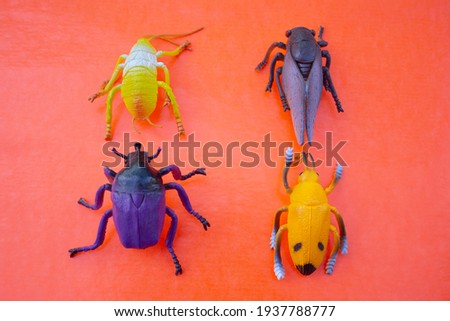 Plastic insect toys on pink background