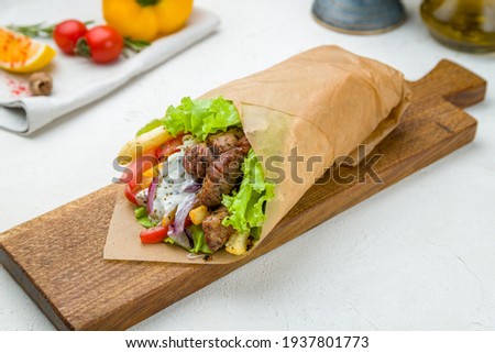 Gyros with beef on the board on white concrete table Greek cuisine Royalty-Free Stock Photo #1937801773