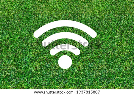 Wi-Fi zone. Free internet sign. Wi-Fi icon on green grass background. Free hotspot in a bar, restaurant, cafe and or park. Radio wave signal. Technology and communication.