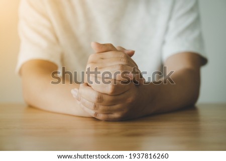 Hand of a man praying hope for better on wood table. Good luck, Success, Forgiveness. Belief of religion Royalty-Free Stock Photo #1937816260