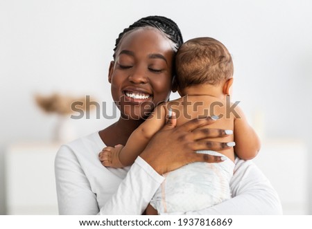African American mom hugging her cute infant Royalty-Free Stock Photo #1937816869
