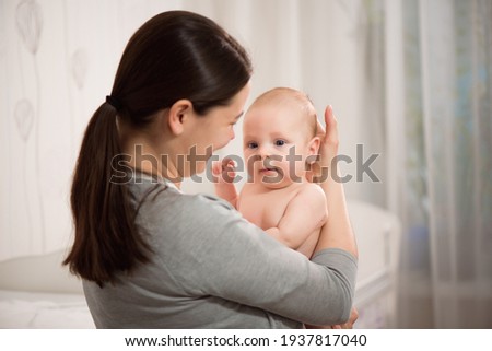 Close up portrait of beautiful young mother girl kissing her newborn baby