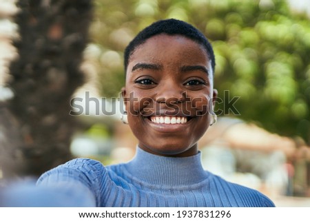 Young african american woman smiling happy making selfie by the camera at the city.