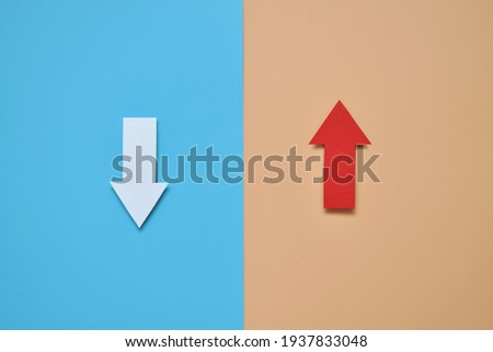 The white arrow points down and the red arrow points up. A symbol of different approaches in life. Different paths Royalty-Free Stock Photo #1937833048