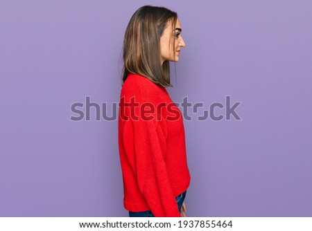 Beautiful brunette woman wearing casual winter sweater looking to side, relax profile pose with natural face and confident smile. 
