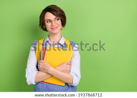 Photo portrait of cheerful student keeping book pile wearing spectacles isolated vivid green color background with copyspace