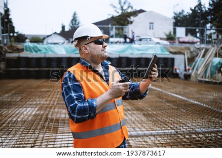 Worker, engineer,communicates with the headquarters on the construction site