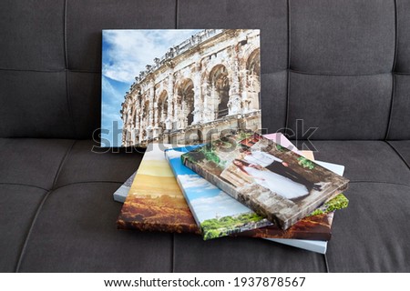 Canvas prints. Photo printed on canvas with gallery wrapping on stretcher bar. Different photos stacked on sofa. Colorful photography