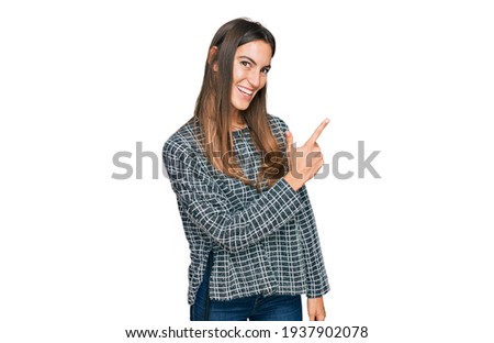 Young beautiful woman wearing casual clothes cheerful with a smile of face pointing with hand and finger up to the side with happy and natural expression on face 