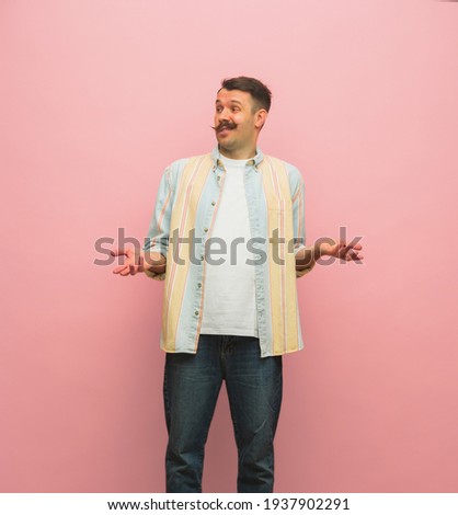 Portrait of young moustached man in casual clothes isolated over light pink background. Concept of human emotions, facial expressions, funny meme emotions, happiness. Copy space for ad.