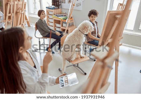 Portrait of a dog student on a  group drawing lesson in a modern light classroom