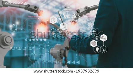 Industry engineer in factory,using smart tablet glass device,control automated robot arm machine learning operation,concept business and industry 4.0,Artificial intelligence or AI,with 5G network Royalty-Free Stock Photo #1937932699