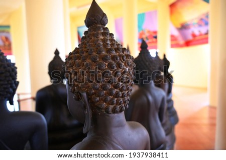Behind the head of a spiral-patterned metal monk covered with gold leaves. Photo of the back of the Buddha image enshrined in the temple's vihara.