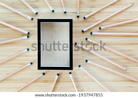 Black picture frame with pencil on a wooden table. design empty frames