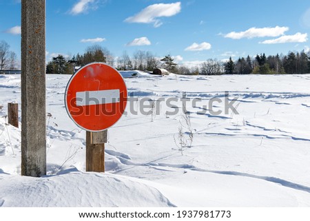Stop road sign covered with snow in winter