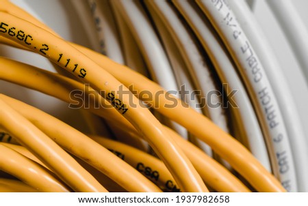 Yellow ethernet cable on a blur white cable background.