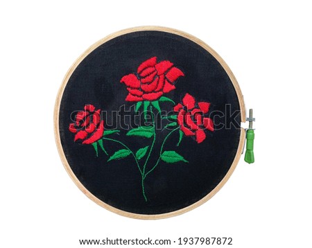 Satin stitch decorations on the black fabric in wooden frame, a satin stitch or damask stitch is a series of flat hand stitches that are used to completely cover a section of the background fabric.