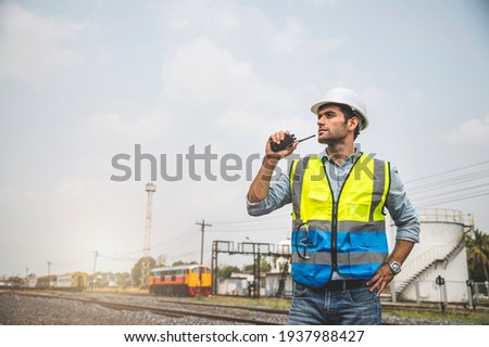Caucasian man railway engineer use walkie-talkie talking in the site work of train garage. Royalty-Free Stock Photo #1937988427