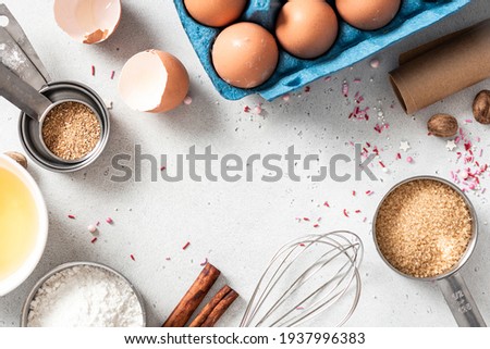 Baking ingredients and kitchen utensils on a white background top view. Baking background. Flour, eggs, sugar, spices, and a whisk on the kitchen table. Flat lay. Royalty-Free Stock Photo #1937996383