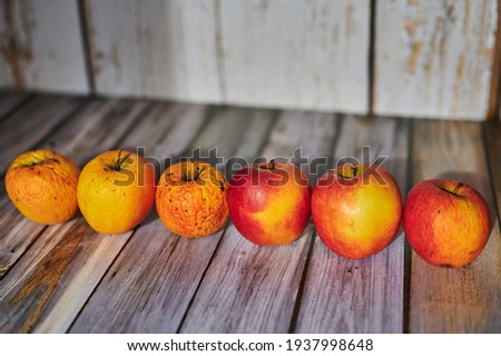 Apples lit from the sun decoratively lying on a wooden underground.