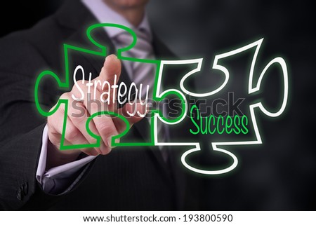 A Businessman pointing at a strategy success puzzle concept.