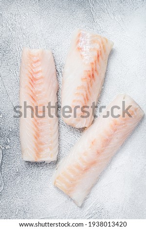Raw Norwegian cod fish fillet on kitchen table. White background. Top view