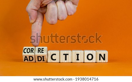 Correction addiction symbol. Businessman turns wooden cubes and changes the word 'addiction' to 'correction'. Beautiful orange background. Business, correction addiction concept. Copy space.