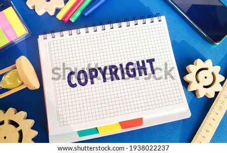 Notebook with the word Copyright. Patenting. Copyright protection. Brand and patent. The fight against online piracy. Gears, hourglass. Blue background