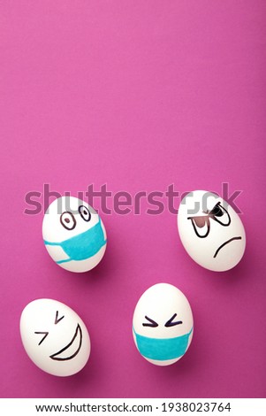 White Easter eggs in protective medical mask and two egg without mask on pink background. Easter on quarantine concept with place for text. Stop VIRUS COVID-19. Copy space.