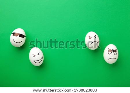 Funny Easter eggs with different emotions on his face on green background. Easter composition. Top view