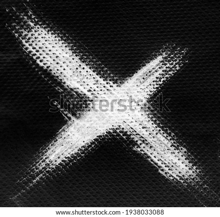 White X ink letter on black background, napkin tissue texture Royalty-Free Stock Photo #1938033088