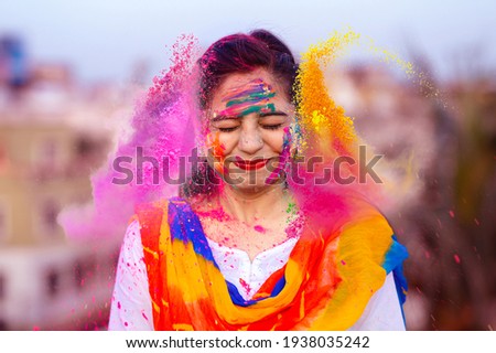 Portrait of happy Indian woman celebrating Holi with powder colours or gulal. Concept of Indian festival Holi. Royalty-Free Stock Photo #1938035242