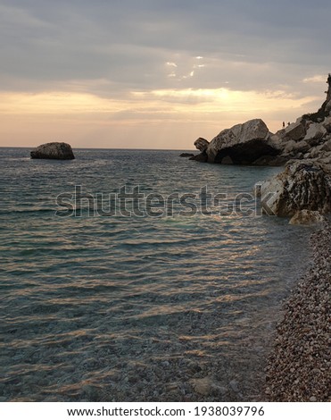 Sunset in the shallows of the Adriatic Sea. The transparent sea mixes with the yellow color of the setting sun.