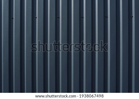 gray metal fence with vertical embossed stripes
