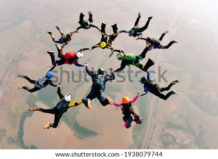 Skydivers holding hands making a formation. High angle view. Royalty-Free Stock Photo #1938079744