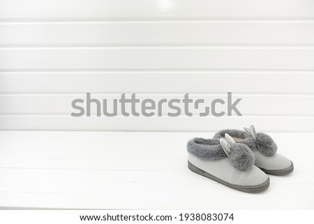 Beautiful fur slippers in the form on a white background, concept of comfort in the house