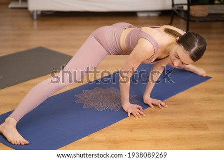 Portrait of beautiful young woman practicing stretching indoor