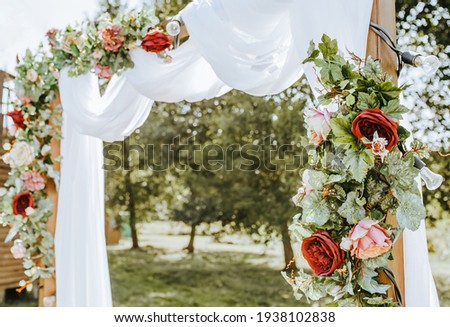 Decorating the arch with flowers and fabric for a wedding ceremony in nature Royalty-Free Stock Photo #1938102838