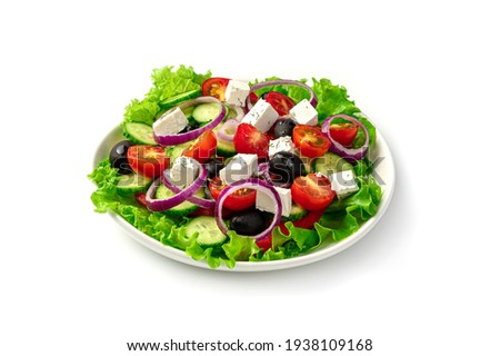 White plate with fresh Greek salad isolated on a white background. Side view, close-up. Royalty-Free Stock Photo #1938109168