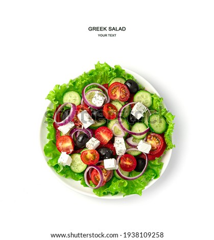 A plate of Greek salad on a white background. Top view. The concept of proper nutrition. Royalty-Free Stock Photo #1938109258