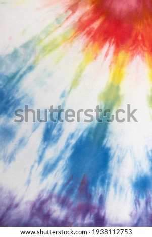 Pastel tie dye, a handmade pattern on a cotton t-shirt. Close-up, top view. DIY concept, handicrafts, original everyday clothes, fabric dyeing techniques. Flat lay, Vertical. Abstract background.