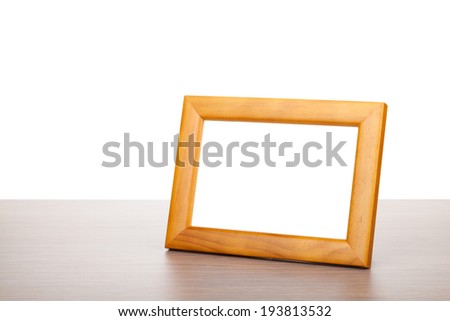 Photo frame on wooden table. Isolated on white background