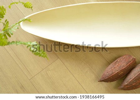 Top view photo of  White bowl.  with Cacao pod. 

white sign board with copy space. 
blurred background soft focus image.