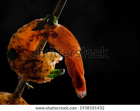 Grilled shrimp closeup on a black background, seafood and grilling cooking.Black background, banner