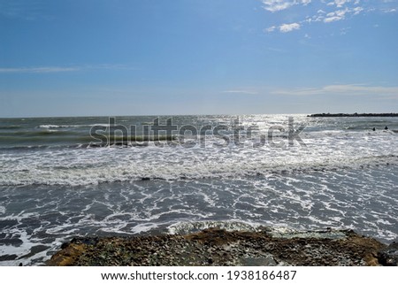 Photography of the wavy sea at the most popular beaches of Mar del Plata City during the summer vacation taken from a pier