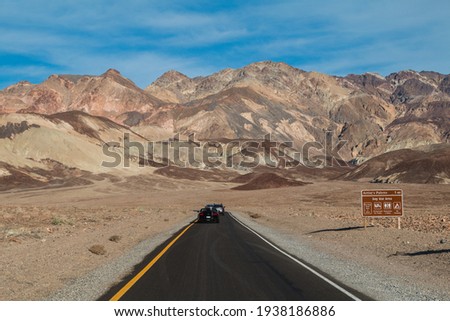 Cars driving down a road in Death Valley