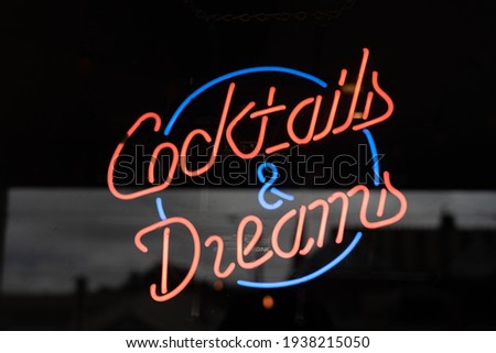 red and blue Neon sign at a pub saying Cocktails and Dreams 